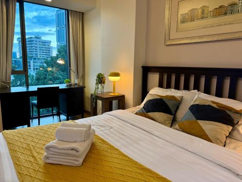 a bedroom with a bed with two towels on it at Cozy Spacious 1BR 3pax GardenView, 700m BTS ThongLo, Samitivej, SKV49, Fast wifi in Bangkok