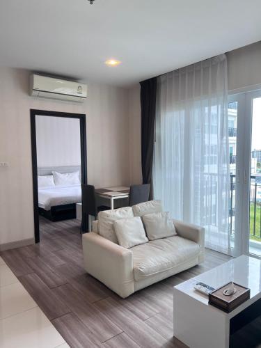 a living room with a couch and a bed at Locals Prio ChiangMai Central Airport Plaza in Chiang Mai