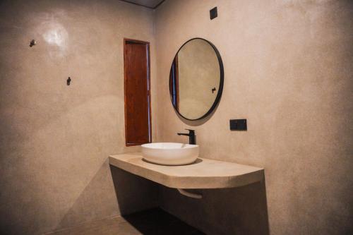 Un baño con un lavabo y un espejo en la pared. en Bela Ahangama, en Ahangama