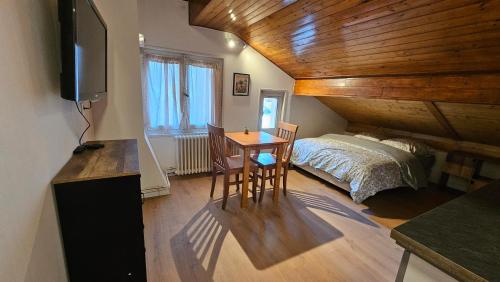 ein Schlafzimmer mit einem Bett und einem Tisch mit Schreibtisch in der Unterkunft Mini cozy au MontBlanc in Sallanches