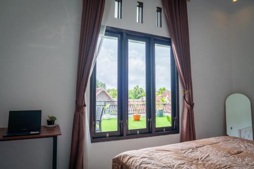 a bedroom with a window with a view of a yard at Micko Homestay, Mantrijeron "Top Rated Value" in Yogyakarta