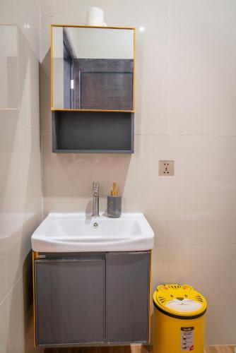 a bathroom with a sink and a yellow trash can at Micko Homestay, Mantrijeron "Top Rated Value" in Yogyakarta