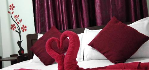two red pillows with hearts on top of a bed at Adb's Srirangam Homes at Gandhi Road in Tiruchirappalli