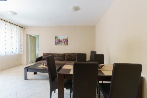 a dining room with a table and a couch at Apartments Lora in Bar