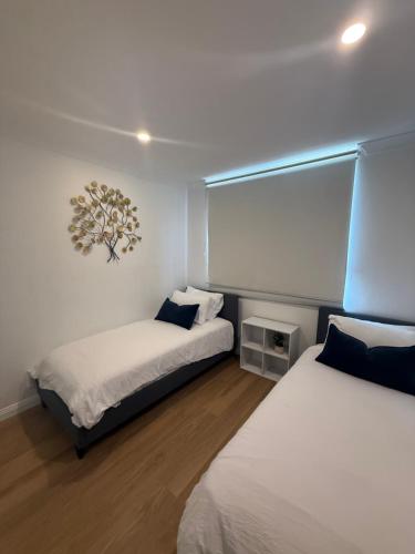 a room with two beds and a window in it at Cosy Apartment close to Manly Beach in Sydney