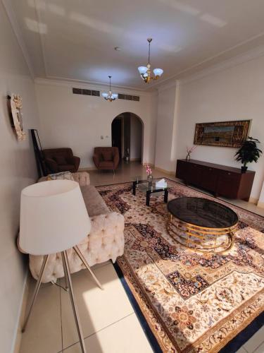 a living room with a couch and a table at Delightful 3Bedroom Family Apartment with Garden View in Sharjah