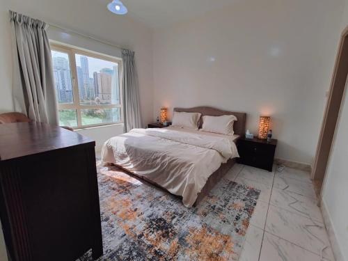 a bedroom with a bed and a large window at Delightful 3Bedroom Family Apartment with Garden View in Sharjah