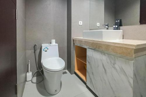 a bathroom with a white toilet and a sink at Apartment Amarta Studio with Living Room in Yogyakarta