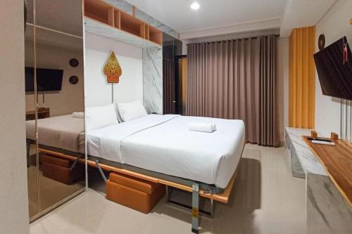 a hotel room with a bed and a mirror at Apartment Amarta Studio with Living Room in Yogyakarta