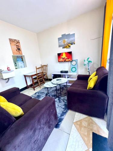 un salon avec deux canapés et une table dans l'établissement House of Hera, à Kisumu