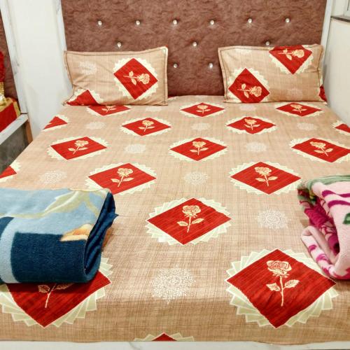 a bed with a quilt and pillows on it at Hotel M S in Pālia