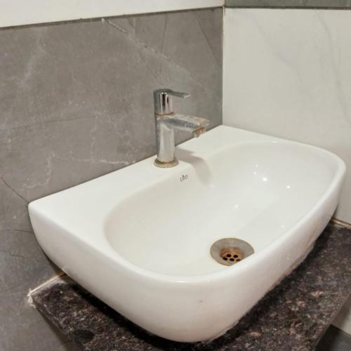 a white sink with a faucet in a bathroom at Hotel M S in Pālia
