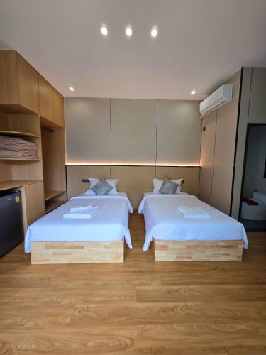 a room with two beds and a tv in it at T&T Bungalow in Ban Khouaphan