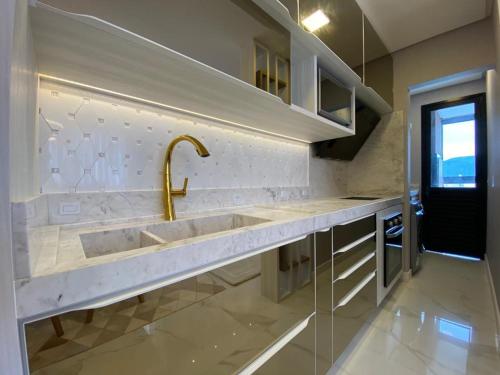 eine Küche mit einer Spüle und einem Wasserhahn in der Unterkunft Apartamento Vó Lêla in Bombinhas