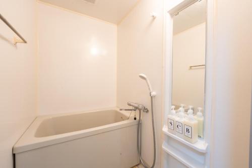um banheiro branco com banheira e chuveiro em Bloomsbury 402 em Wada