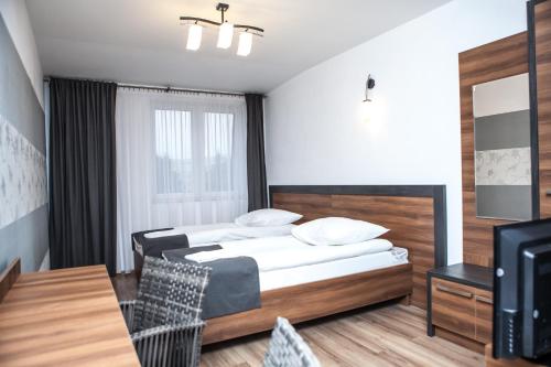 una camera con letto, tavolo e TV di Hotel Bukowiec a Legionowo