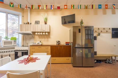 a kitchen with a white table and a refrigerator at Kaunas Center Hostel - Self-Check In in Kaunas