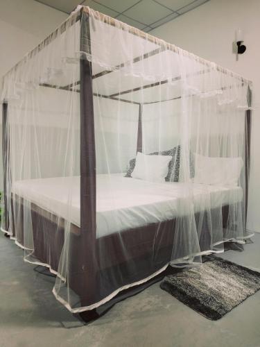 a canopy bed with mosquito netting in a room at Amelia Villa in Gandara West