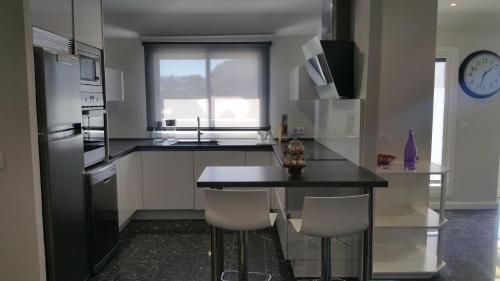 una cocina con encimera negra y electrodomésticos blancos en Apartamento Castrelos, en Vigo
