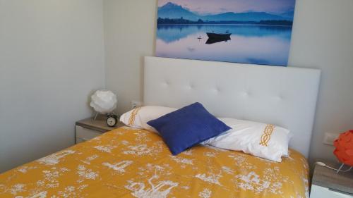 Apartamento Castrelos في فيغو: غرفة نوم بسرير مع لوحة على الحائط