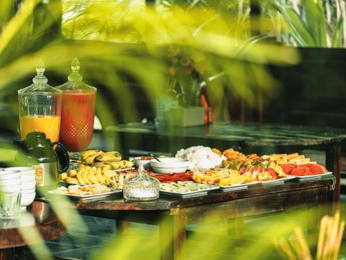 een tafel gevuld met verschillende soorten voedsel op borden bij Ninh Binh Mountain Resort in Xuân Sơn