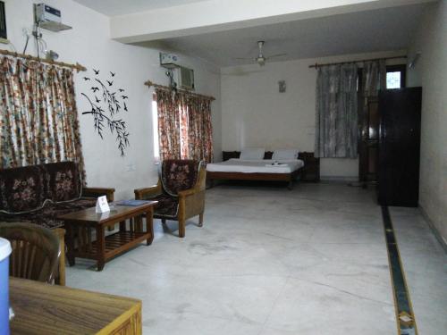 a living room with a couch and a table at Hotel Mayur in Gwalior