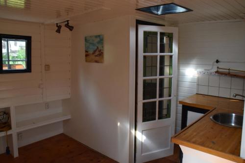 a kitchen with white walls and a sink and a counter at Boat-Apartment Rotterdam Fokkelina in Rotterdam