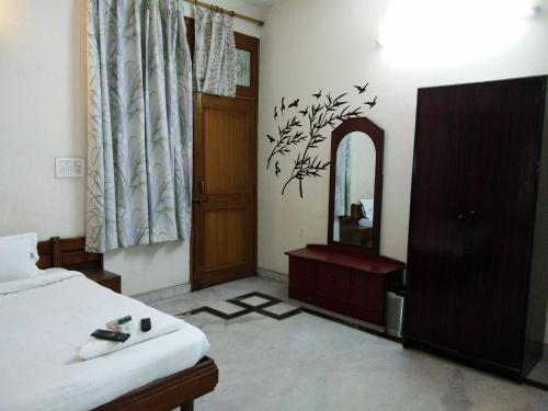 a bedroom with a bed and a mirror at Hotel Mayur in Gwalior