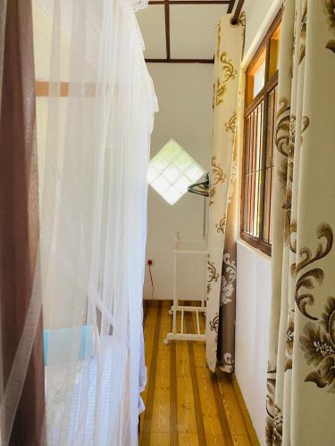 a hallway with a white curtain and a window at Romaclan Villa in Midigama East