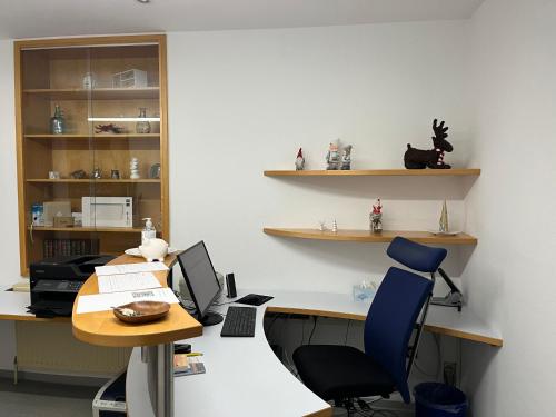 una oficina con un escritorio con una computadora y una silla en Rosis Appartement, en Wiener Neustadt