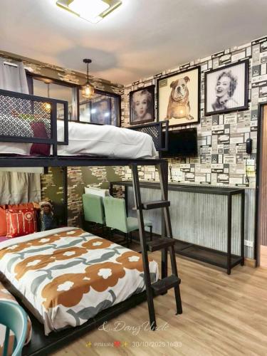 a bedroom with a bunk bed and a wall with pictures at โรงแรม เลิฟ บีเคเค in Amphoe Phra Khanong