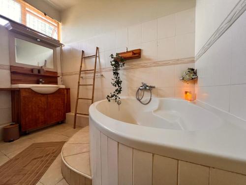 a large white tub in a bathroom with a sink at Bazaar Square Lodges in Grand-Baie