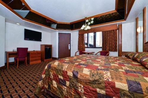 a hotel room with a bed and a desk at Americas Best Value Inn & Suites Los Angeles Downtown SW in Los Angeles