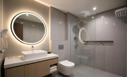 a bathroom with a sink and a toilet and a mirror at رويال علاء للشقق الفندقيه in Dubai