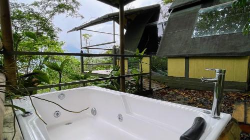 ANCESTRAL GLAMPING في باربوسا: حوض استحمام أبيض أمام منزل