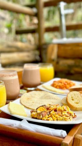 een tafel met een bord eten met brood en kaas bij ANCESTRAL GLAMPING in Barbosa