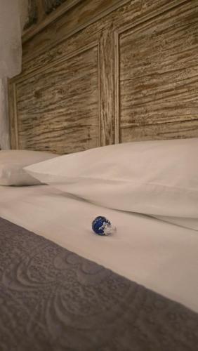 een blauwe kraal die op een bed ligt bij Dimora Storica Gold Room in Ruviano