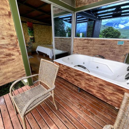 a bath tub sitting on a deck with a chair at ANCESTRAL GLAMPING in Barbosa