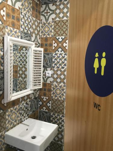 
a bathroom with a sink and a mirror at Hostel D'Avenida in Vila Praia de Âncora
