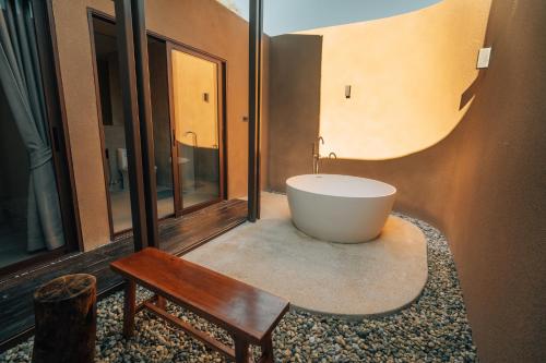 The Fam Cafe&Resort Chiangdao في تشينغ داو: حمام مع حوض استحمام ومقعد