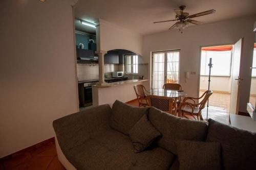 a living room with a couch and a kitchen with a table at Vila Vistazul in Pataias