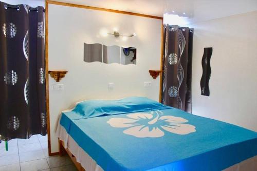 a bedroom with a bed with a blue comforter at Moorea Vaiare Lodge in Moorea