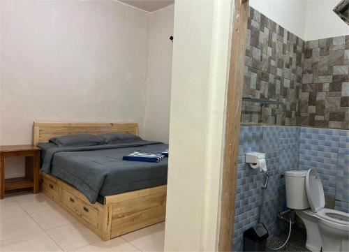 a bedroom with a bed and a toilet in a bathroom at FOUR-G Home Stay & Komodo Tour in Labuan Bajo