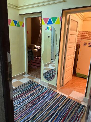 a room with a door open to a room with a refrigerator at SolNest Guest House in Aswan