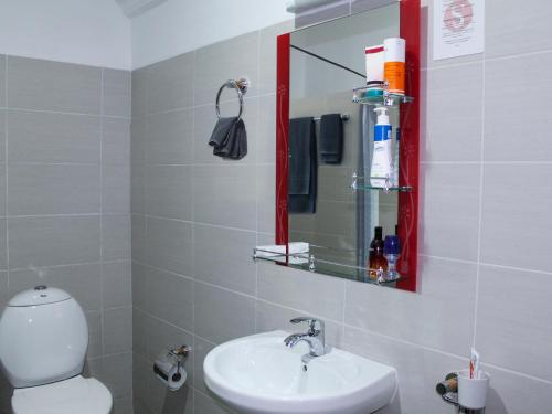 ein Badezimmer mit einem WC, einem Waschbecken und einem Spiegel in der Unterkunft 5 Swiss Hotel in Kigali