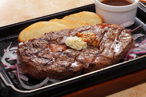 Un filete en un recipiente negro con salsa y pan. en Aizuwakamatsu Washington Hotel, en Aizuwakamatsu