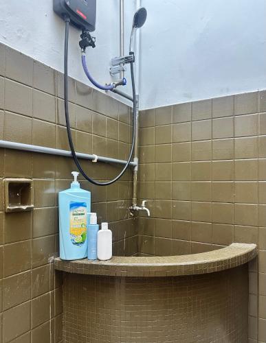a bathroom with a shower with a bottle of soap at Little Stay Inn in Taiping