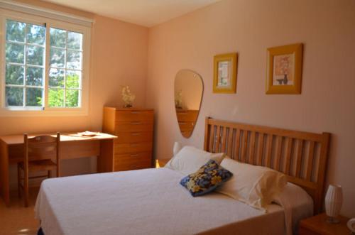 a bedroom with a bed and a desk and a mirror at Apartamento Atis Tirma in Gran Tarajal