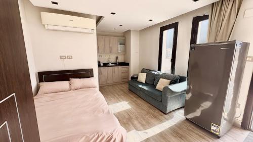 a small living room with a couch and a refrigerator at Modern Rooftop Studio in Westown, Sheikh Zayed - Near GEM & SPX Airport in Sheikh Zayed