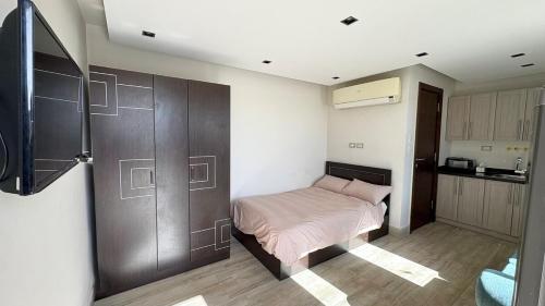 a bedroom with a bed and a wooden wall at Modern Rooftop Studio in Westown, Sheikh Zayed - Near GEM & SPX Airport in Sheikh Zayed